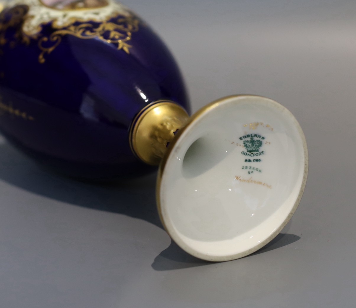 An early 20th century Coalport porcelain vase painted with a view of lake Windermere on a cobalt blue and ivory ground, height 29 cms.